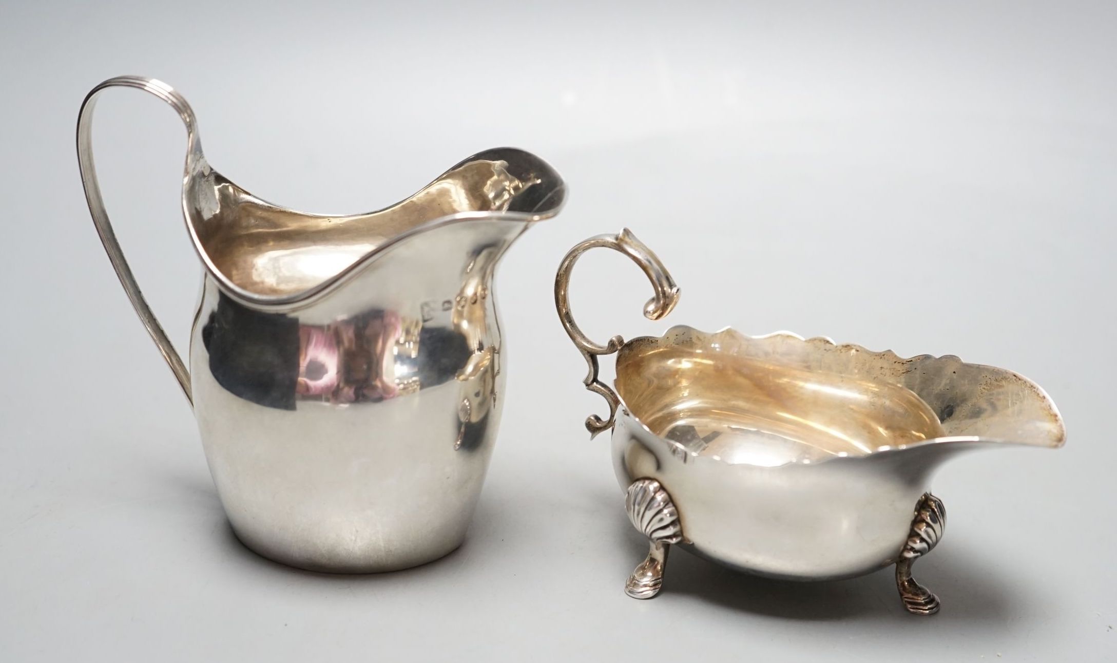 A George III silver jug, London, 1798, a silver sauce boat and pair of silver mounted dwarf candlesticks.